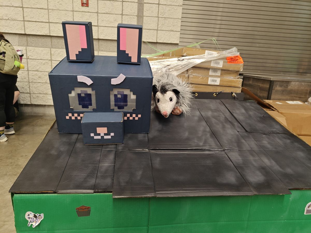 Pixel-style cat head made of cardboard box wrapped in dark blue
paper