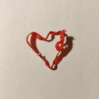 A dusty red twist tie bent into a heart.