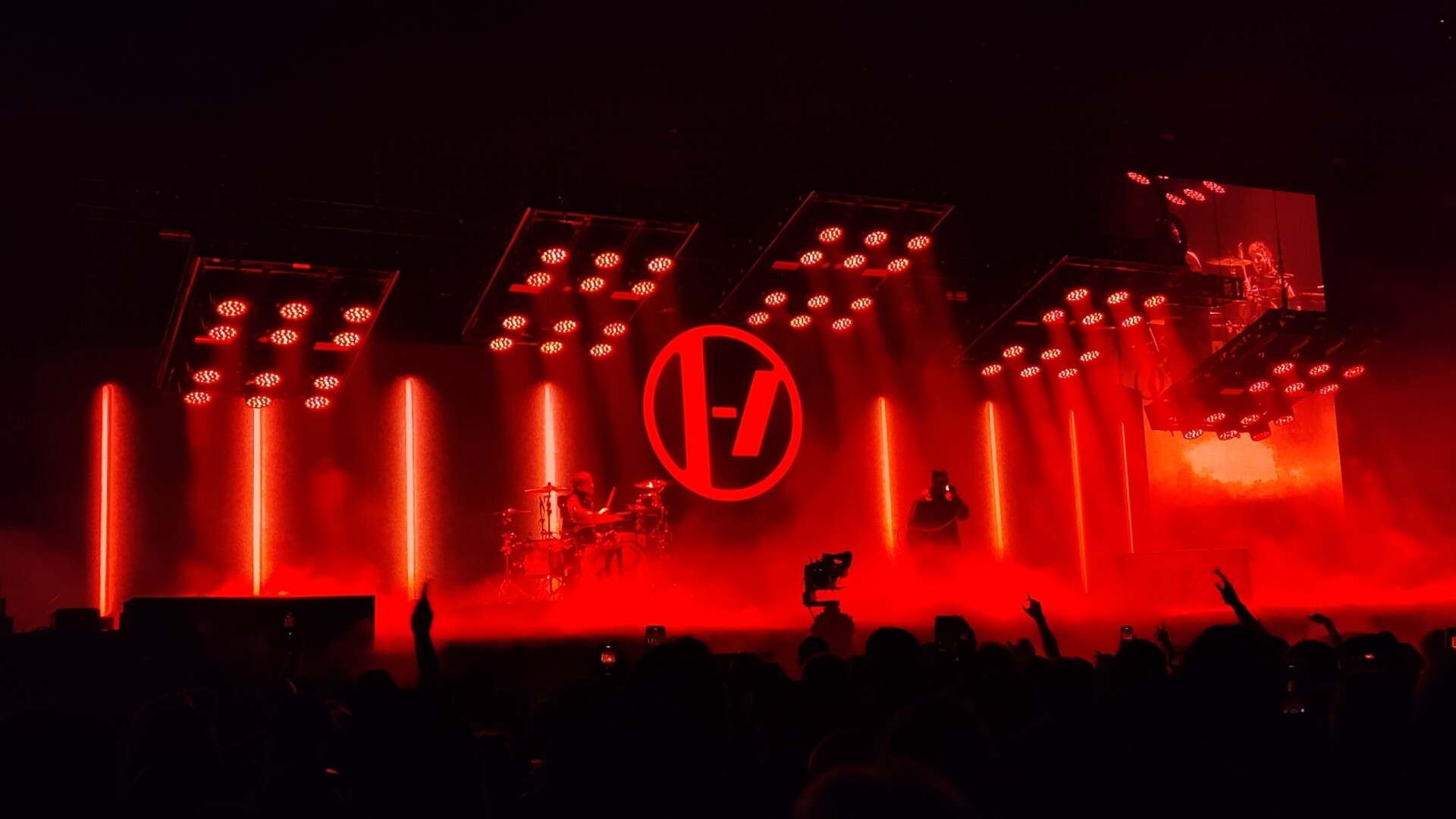 Tyler and Josh performing under red stage
light