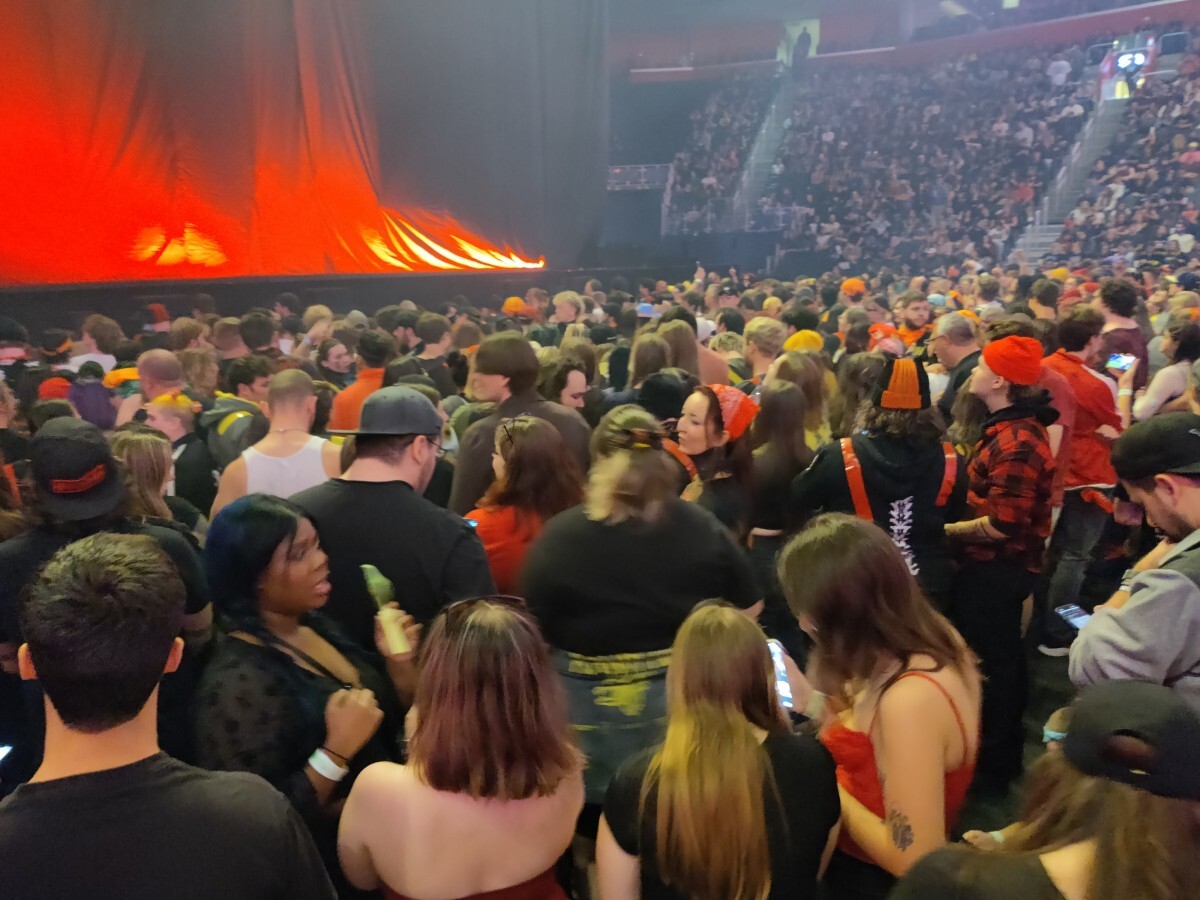 Mosh pit crowd. Most are wearing some sort of yellow or red
item.