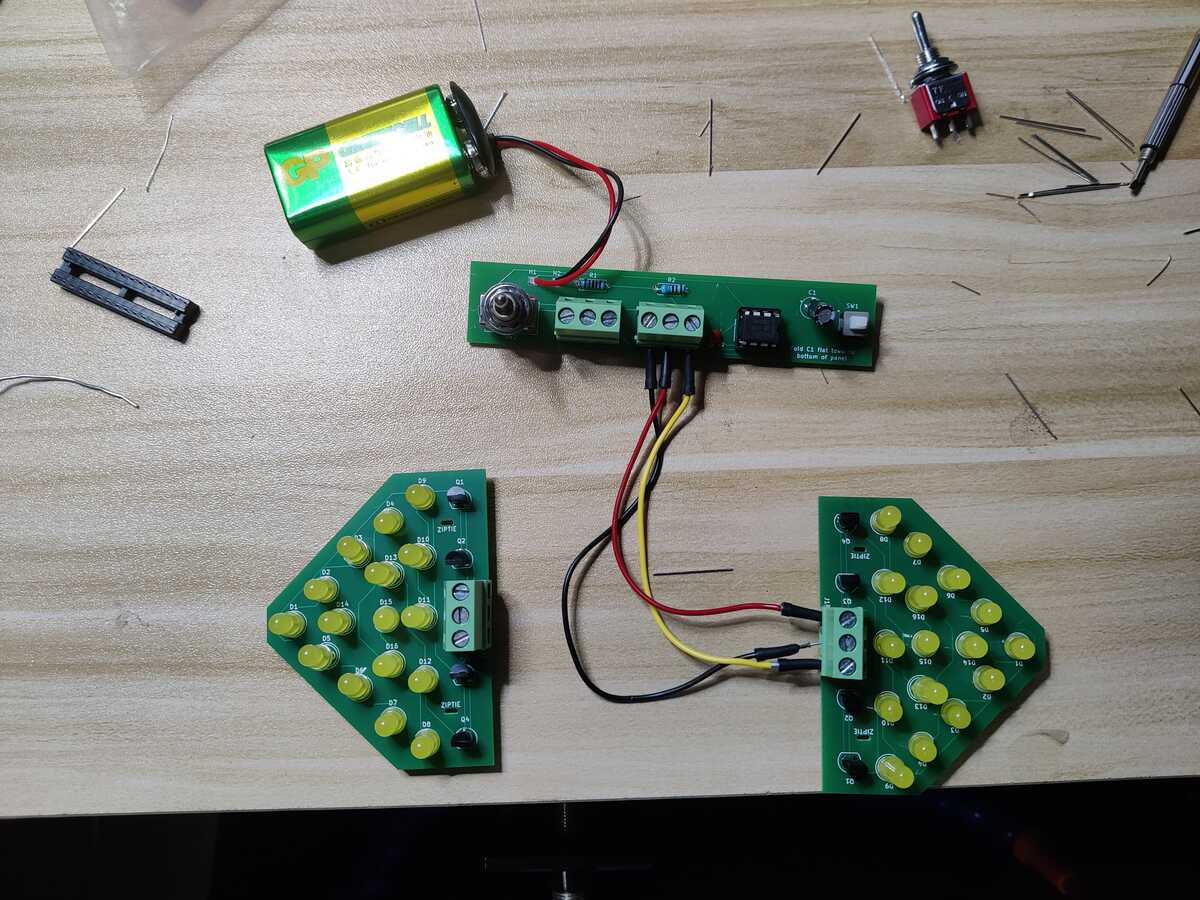 
        A controller PCB connected to an LED panel via 3 jumper wires.
        Another LED panel is beside, but unconnected. There are 16 yellow
        LEDs on each panel.
    