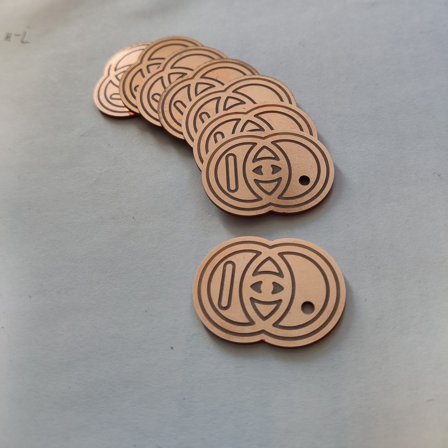 A stack of bare-copper PCBs carrying a logo