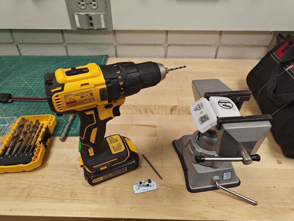 Cordless drill next to the plastic enclosure in
a clamp