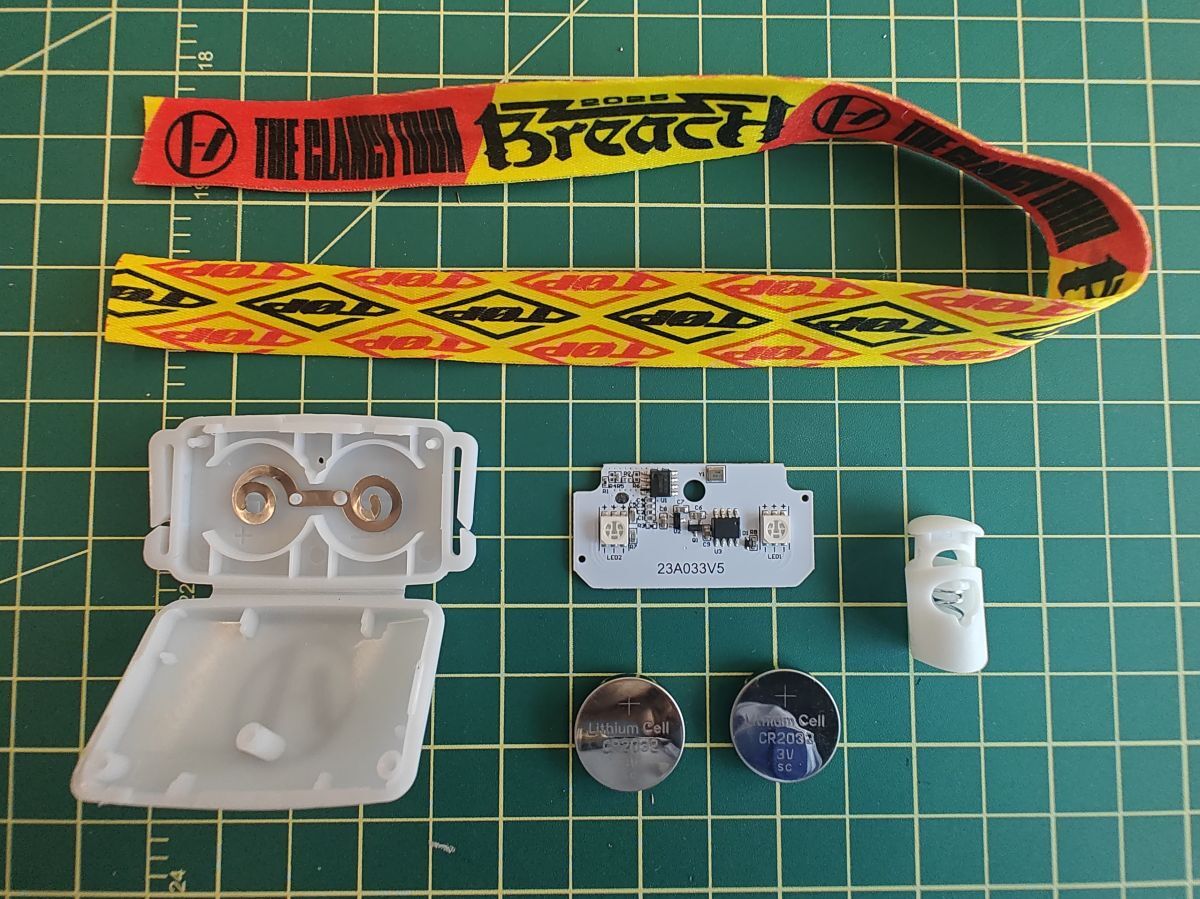 Disassembled wristband on cutting mat, showing PCB, enclosure, coin cells, and
strap