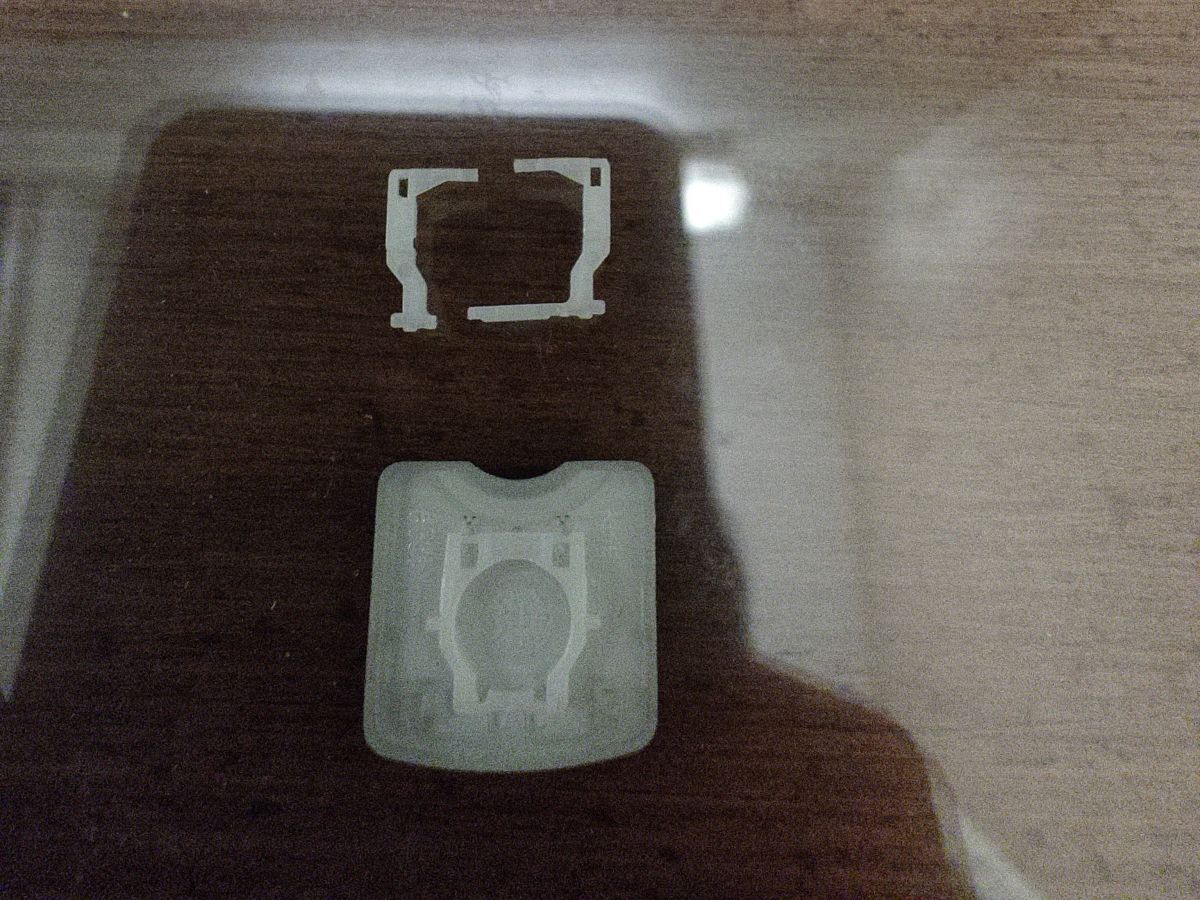 Keycap upside down, revealing a piece of plastic broken in
two