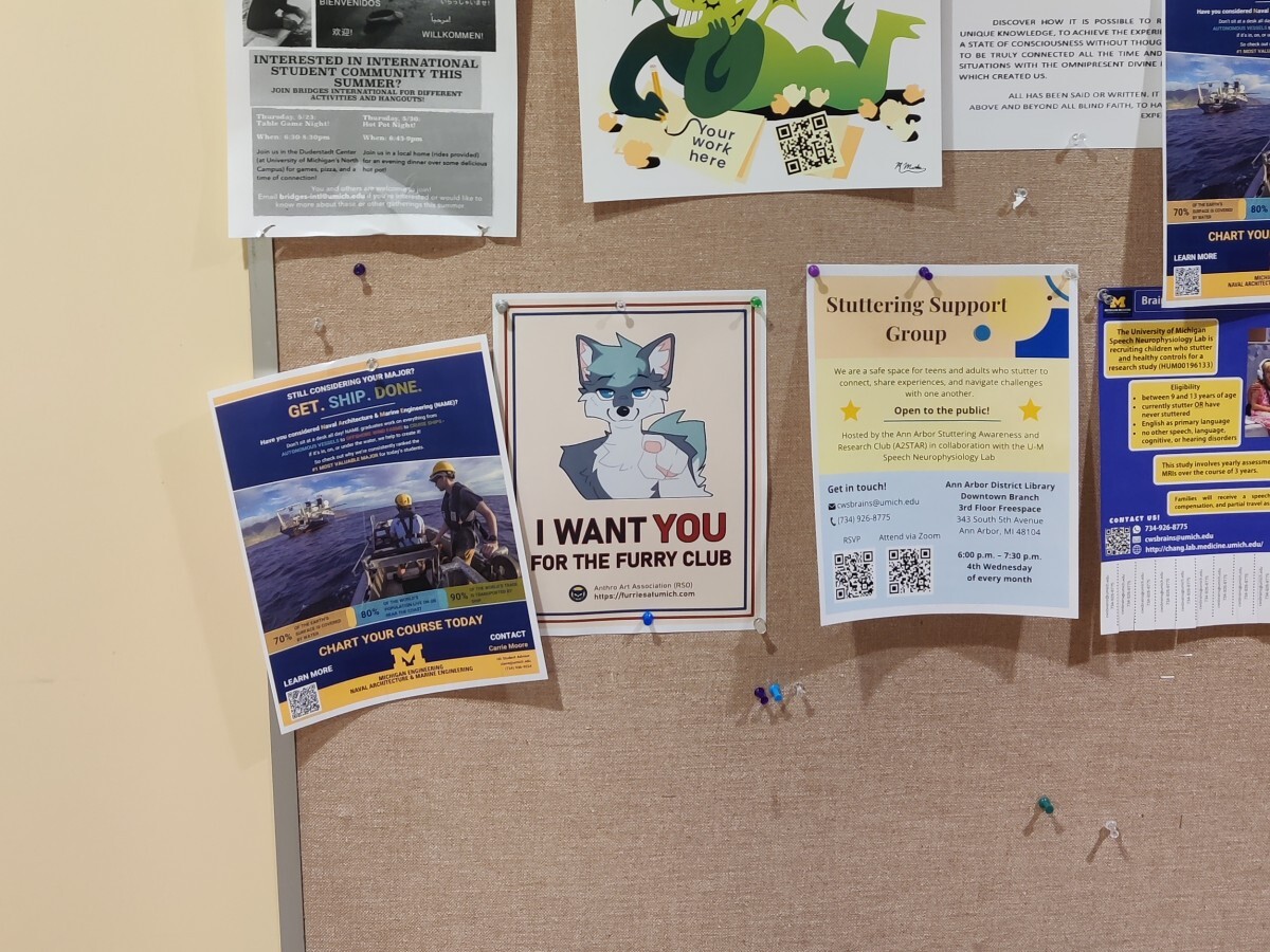 Poster on a bulletin board. Grey anthro dog staring menacingly and
pointing at you. Caption reads "I want you for the furry club". URL runs
underneath.