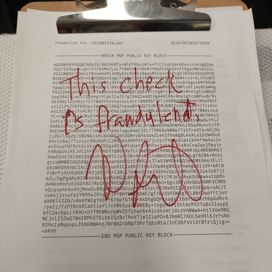 My PGP key printed on a sheet of paper. On top of it written in red is
"This check is fraudulent" and Diffie's
autograph