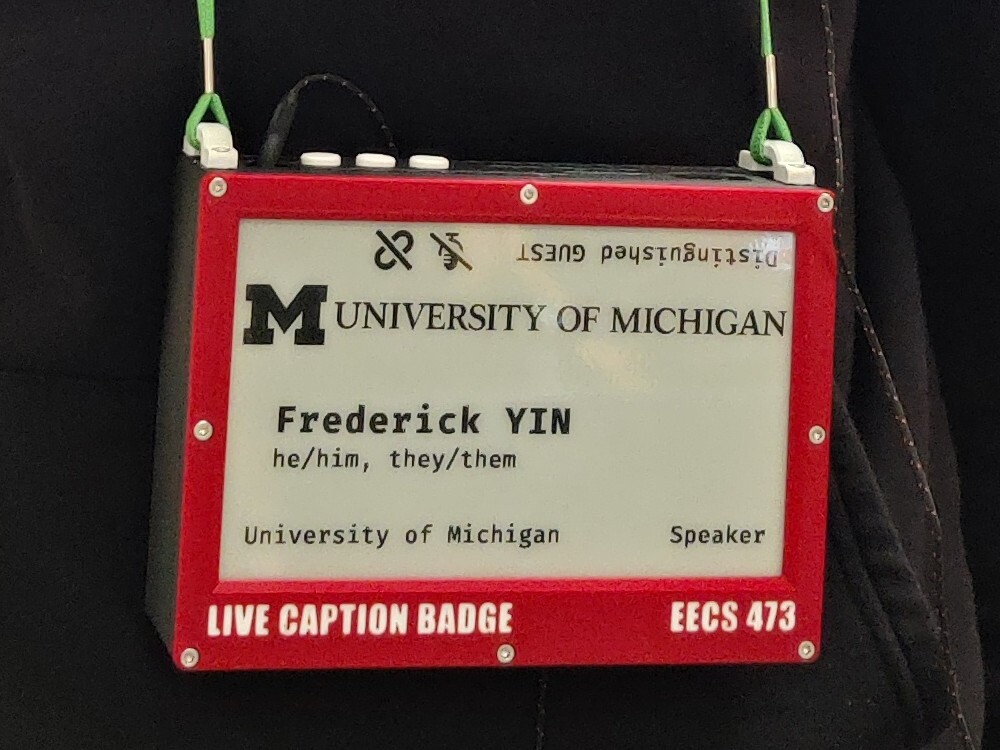 An e-paper display in a 3D-printed box. On the screen is the UMich logo,
Frederick Yin, he/him, they/them, Speaker.