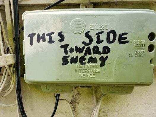 An AT&T network interface device, scribbled "this side toward enemy" in
all caps with a chisel-end
marker